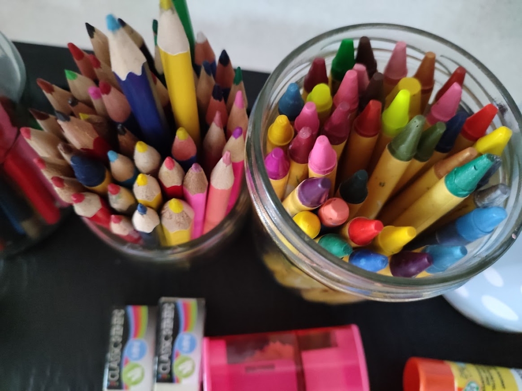 Gros plan vue de dessus de pots de crayons de couleurs et craies grasses