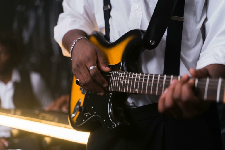 Gros plan sur un les main d'un guitariste qui joue de la basse
