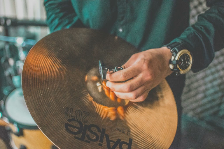 gros plan sur les mains d'une personne qui monte une cymbale