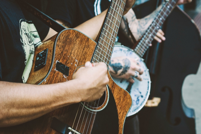 gros plan sur les mains d'un guitariste, joue sur une guitare acoustique